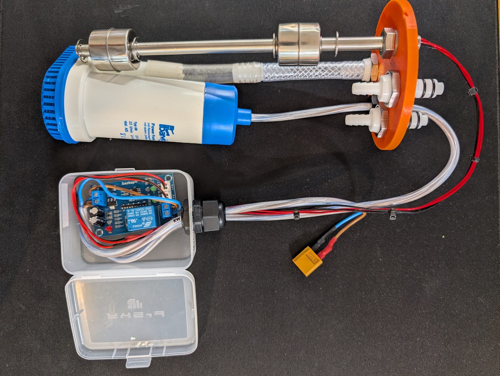 The complete internals laid out — pump, float switch, hoses, lid and controller