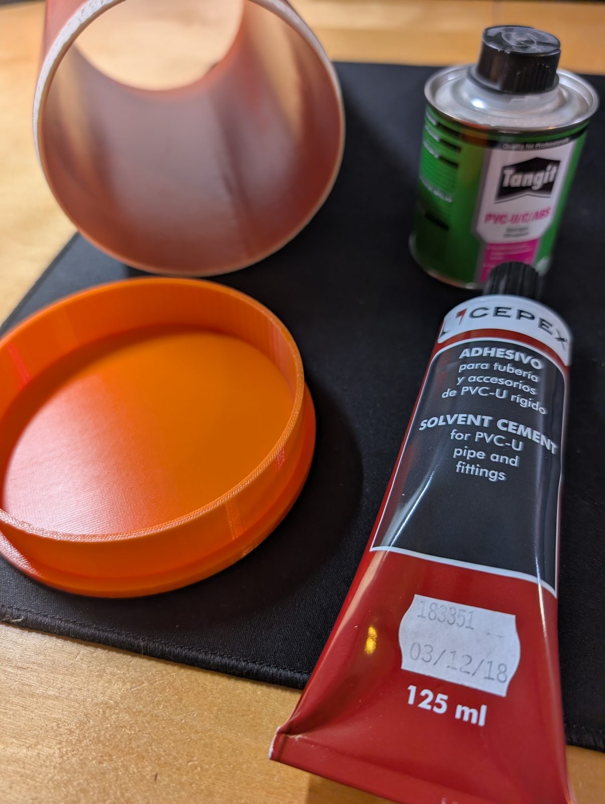Two tins of PVC solvent cement next to the printed floor